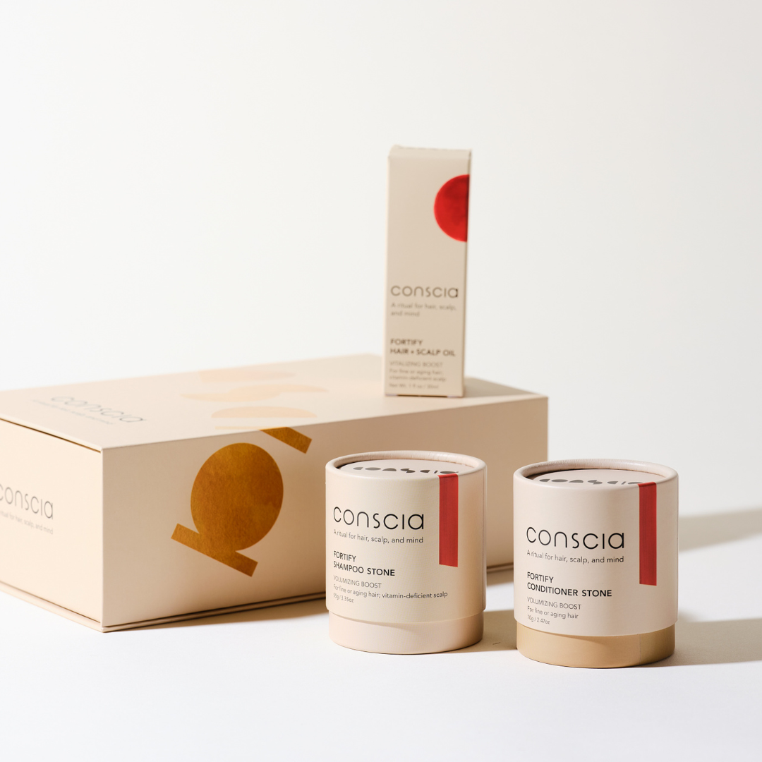Conscia skincare products including a box, bottles, and containers on a light background