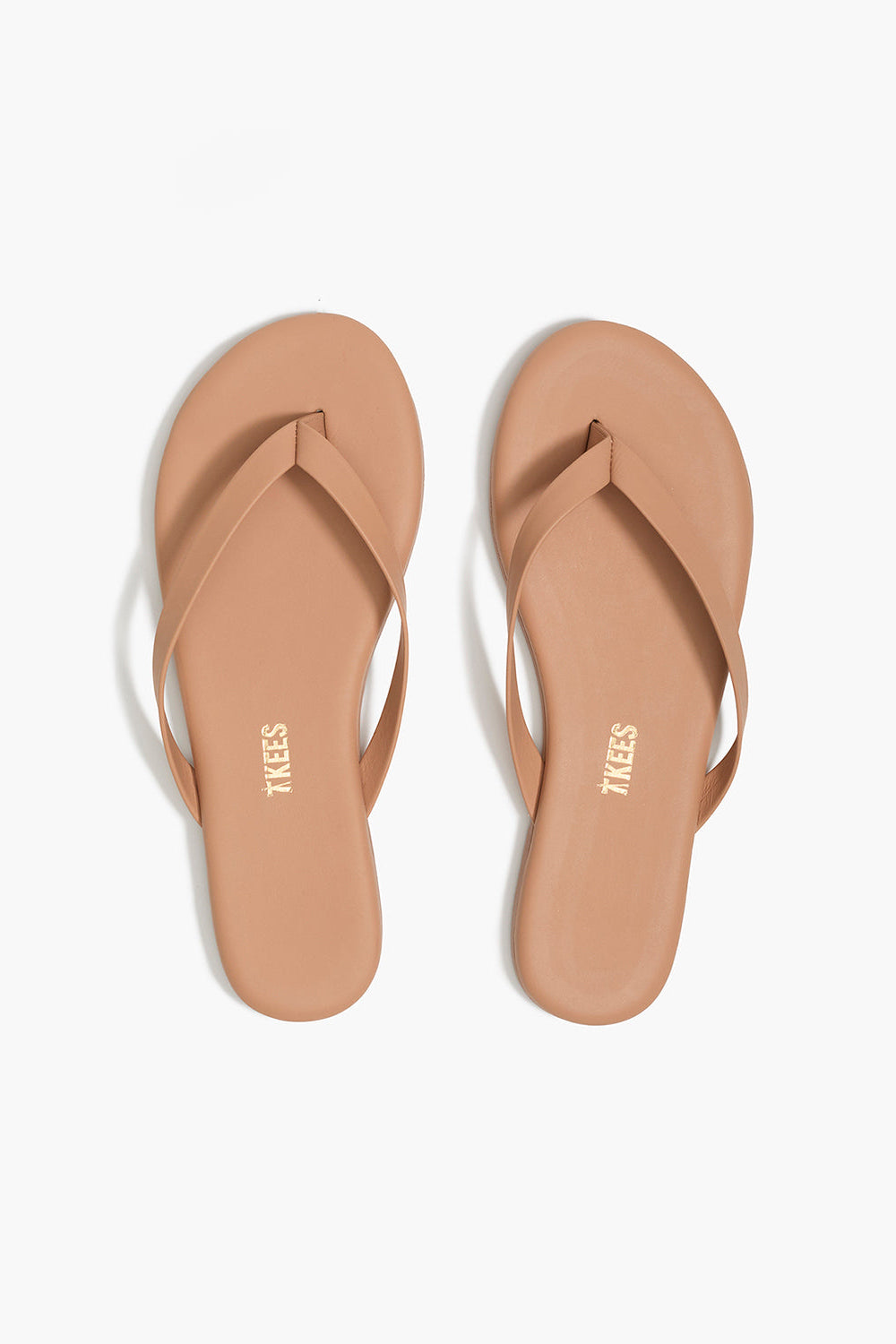 Pair of tan flip-flops on a white background