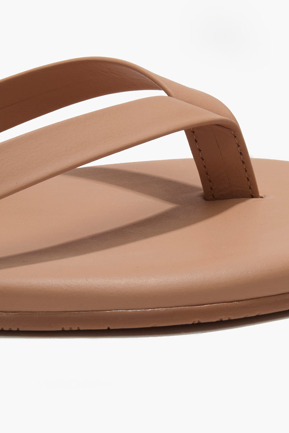 Brown sandal with a single strap on a white background