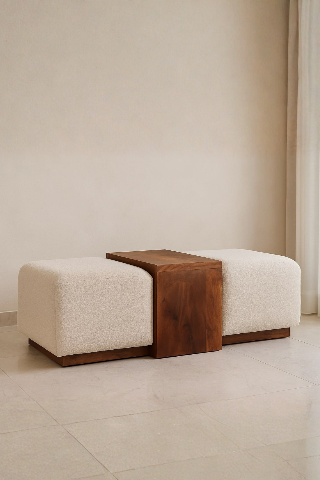 Modern bench with wooden bench seat and cream colored boucle-upholstered cushions in a minimalistic setting