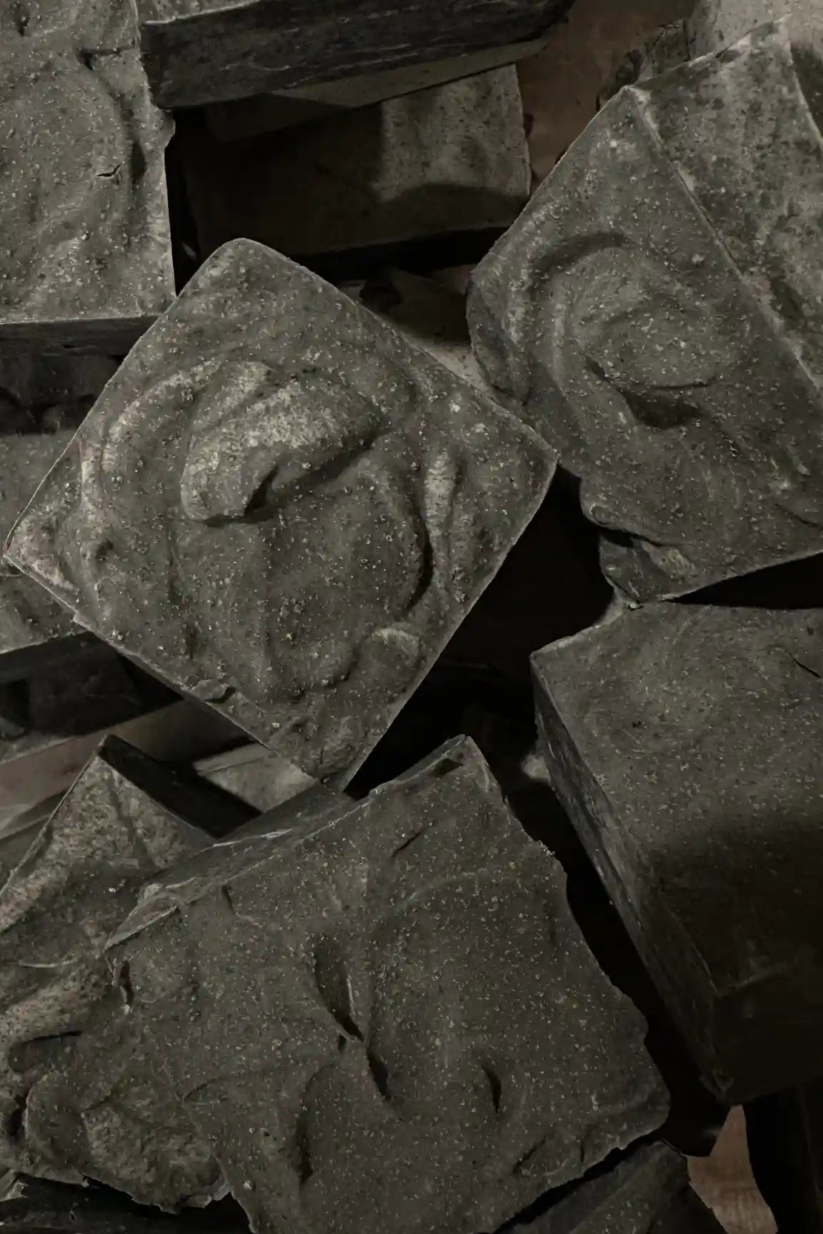 Stack of dark soap bars with a textured surface