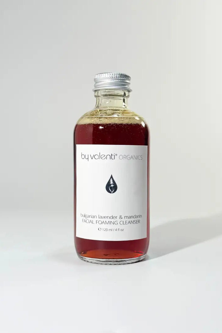 Bottle of By Valenti Organics facial cleansing product on a white background