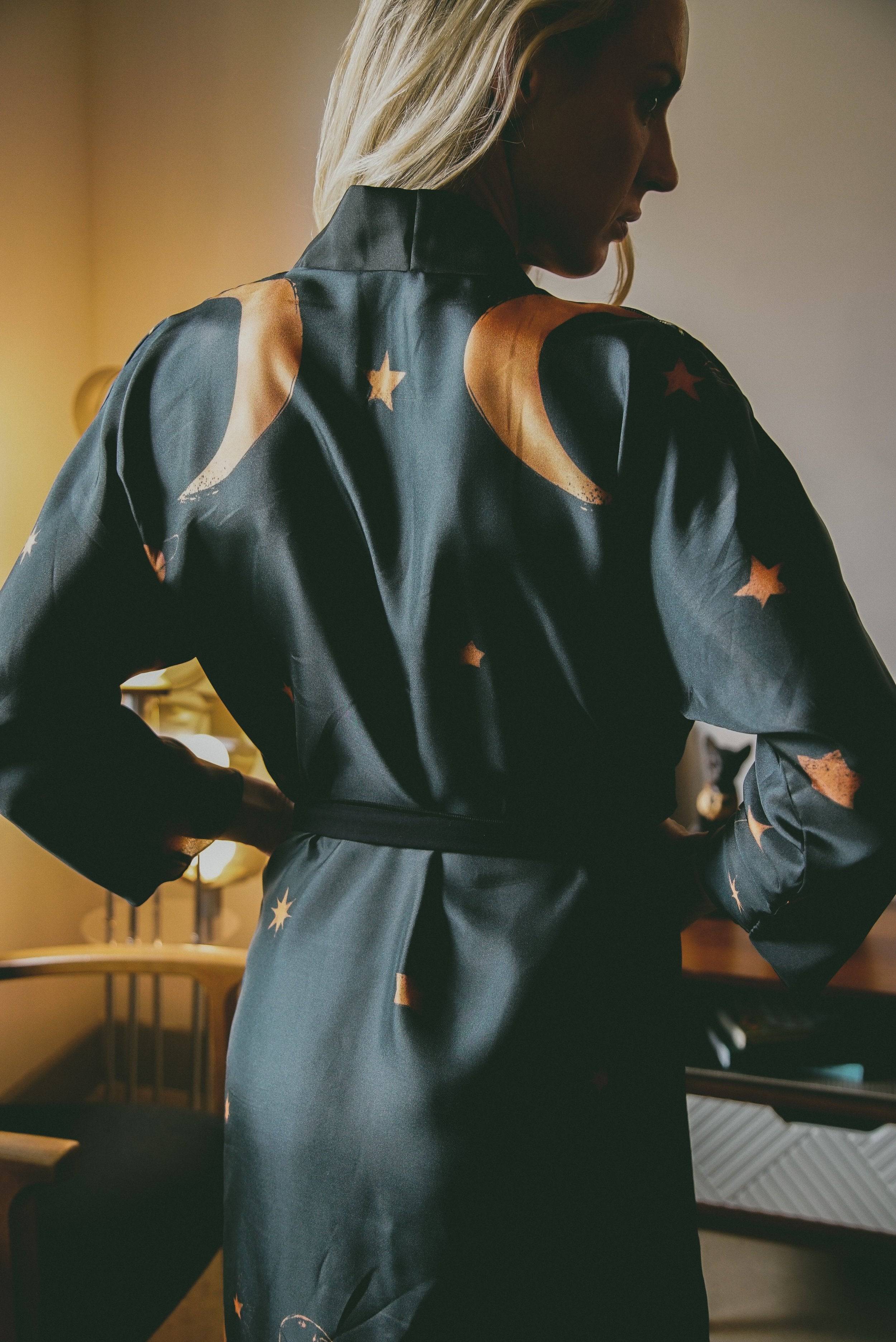 Person wearing a dark blue jumpsuit with star patterns in an indoor setting