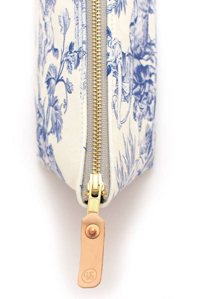 Round pouch with blue floral pattern and gold zipper on a white background