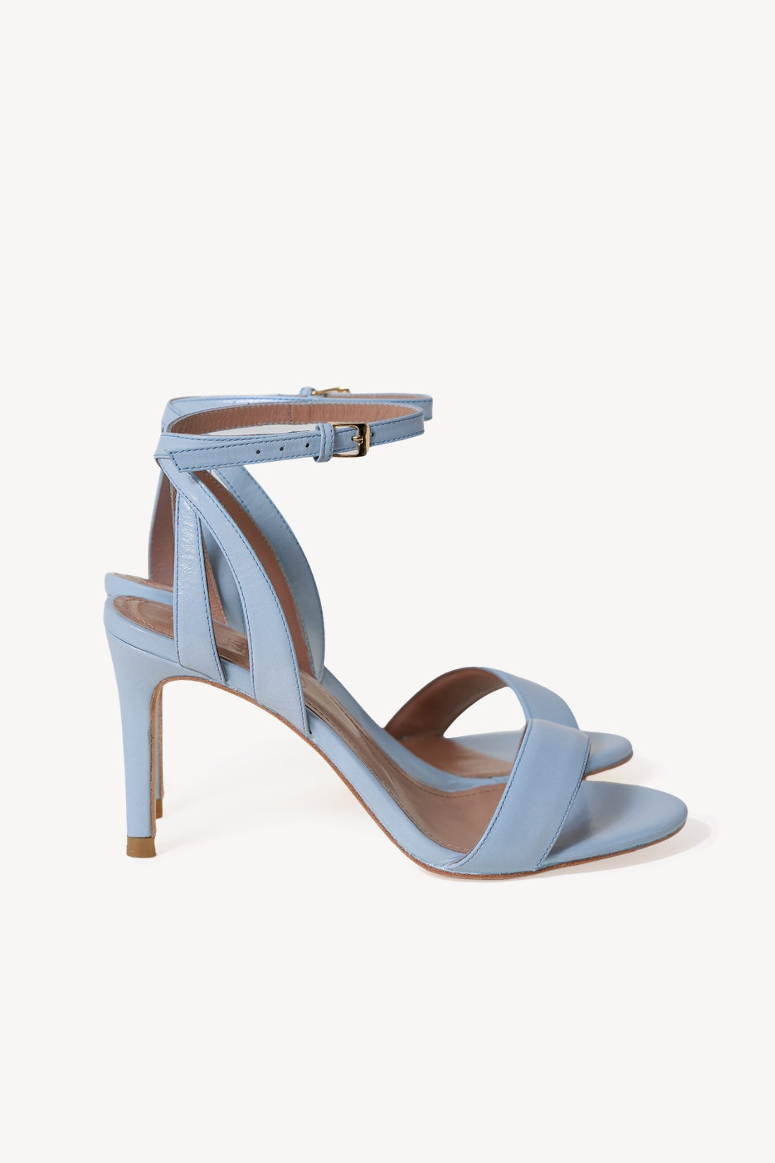 A pair of light blue leather high-heeled sandals with an ankle strap and criss-cross front straps, shown from a side profile on a light off-white background.