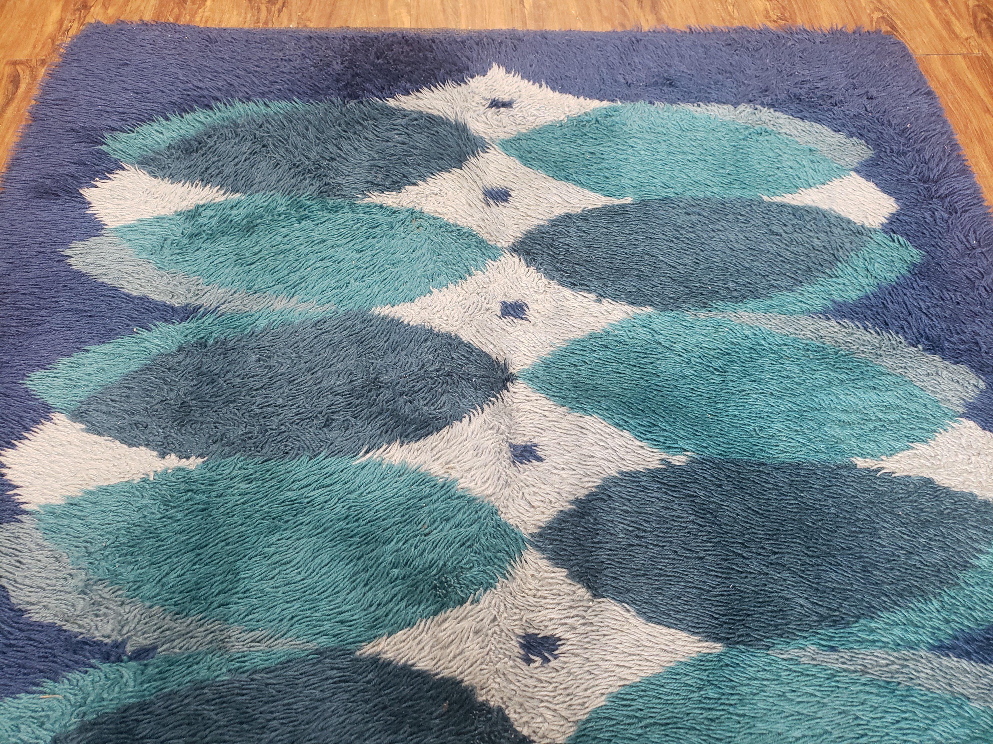 Geometric patterned rug with blue and green colors on a wooden floor.