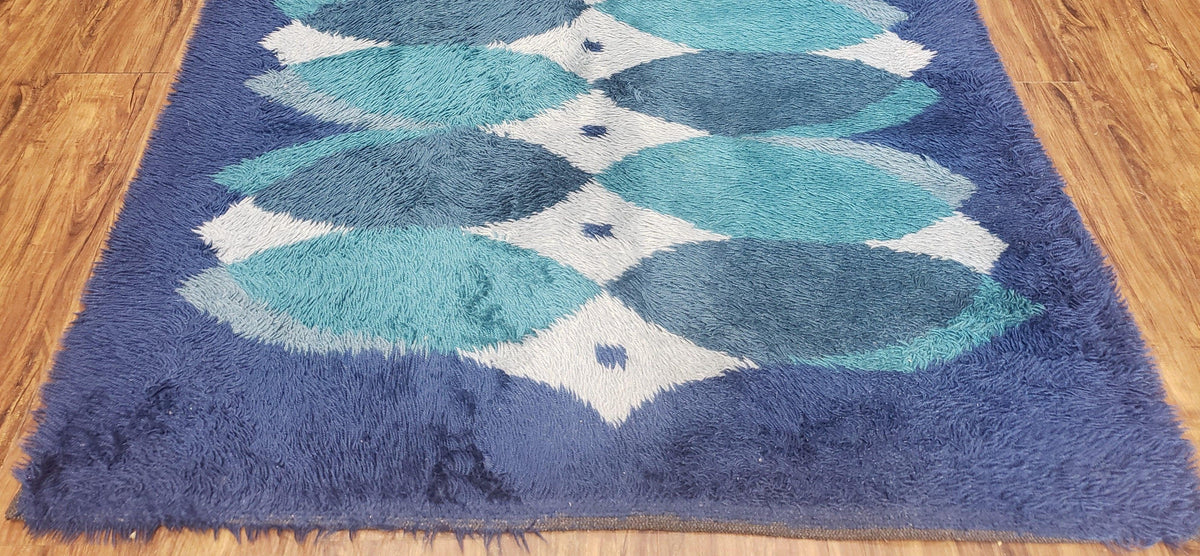 Blue and green patterned rug on a wooden floor