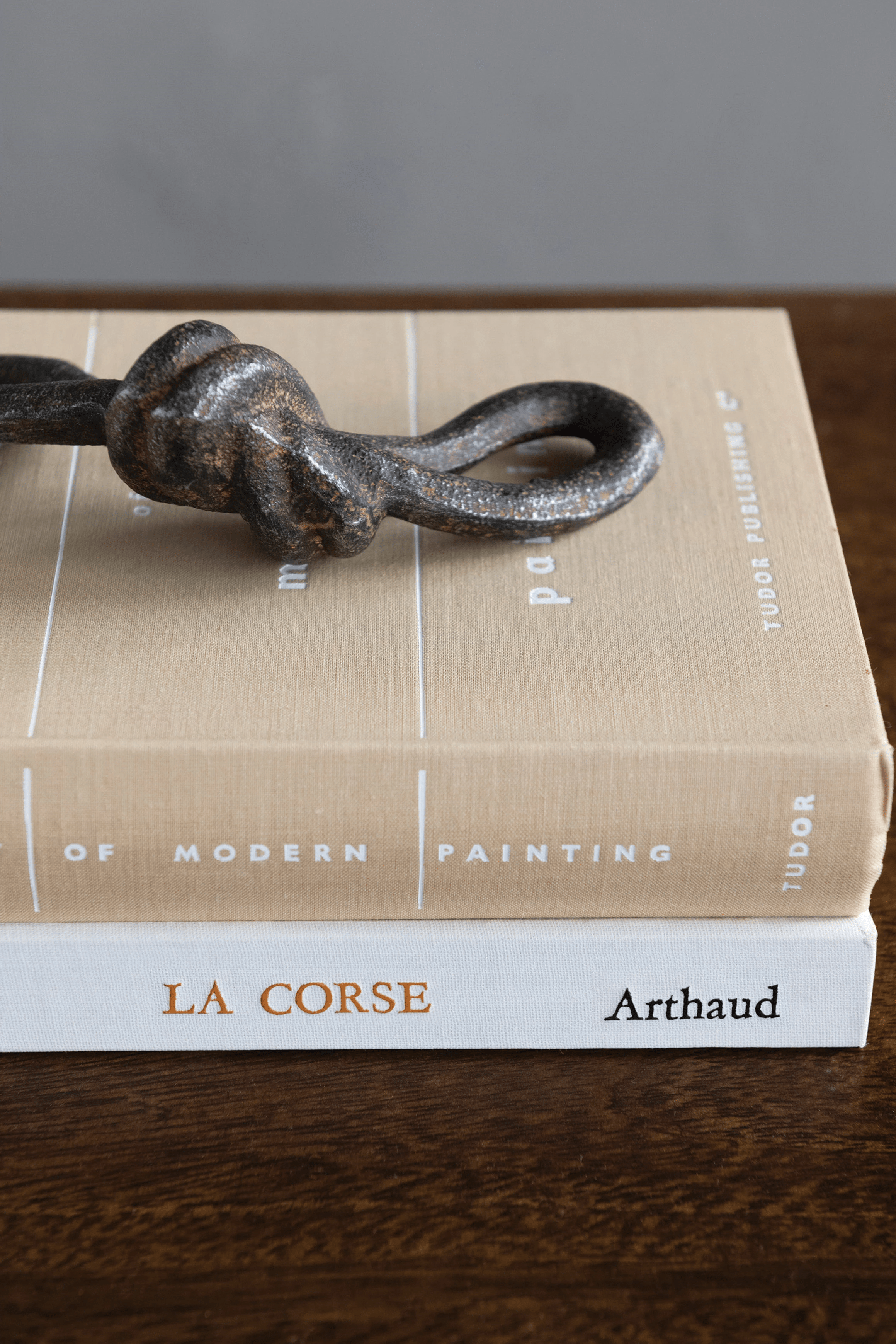Book with a metal knot on top, titled 'La Corse Arthaud' on a wooden surface.