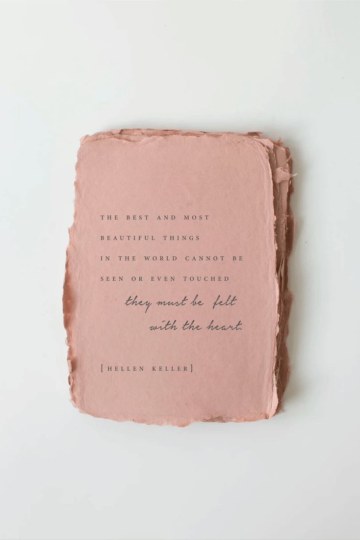 Pink textured book with a quote by Helen Keller on a white background