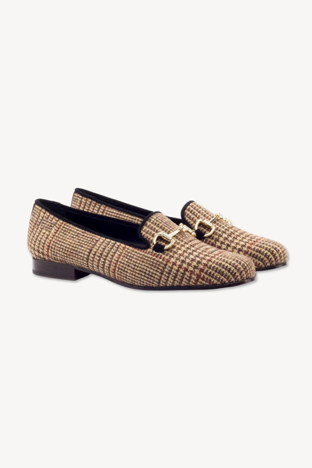 Pair of woven loafers with a gold buckle on a white background