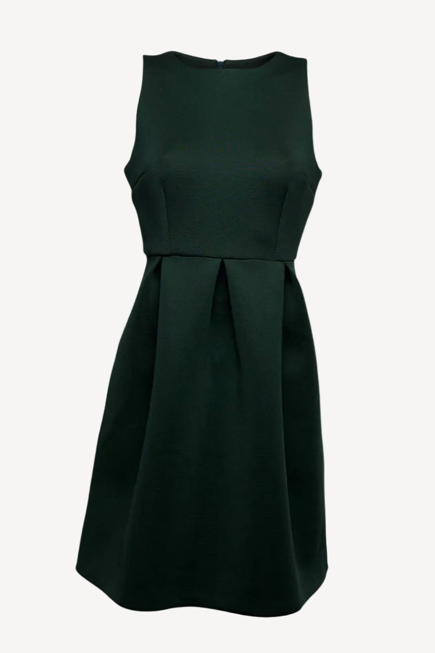 A sleeveless, knee-length green dress with a round neckline and large pleats in the front, made of neoprene fabric.