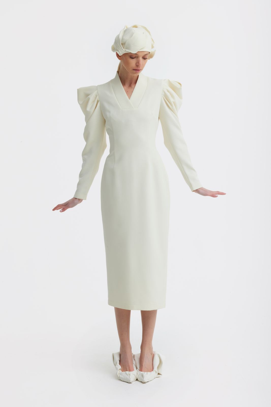 Woman wearing a white dress with puff sleeves on a white background