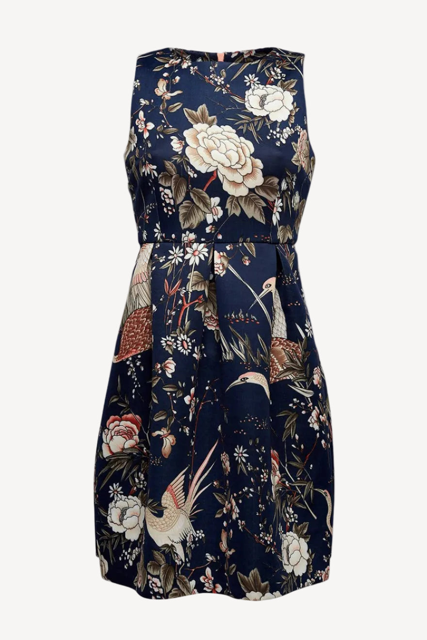 A sleeveless knee-length dress with a Japanese bird print, featuring an empire waist and large pleats, in navy color with a visible pink zipper.