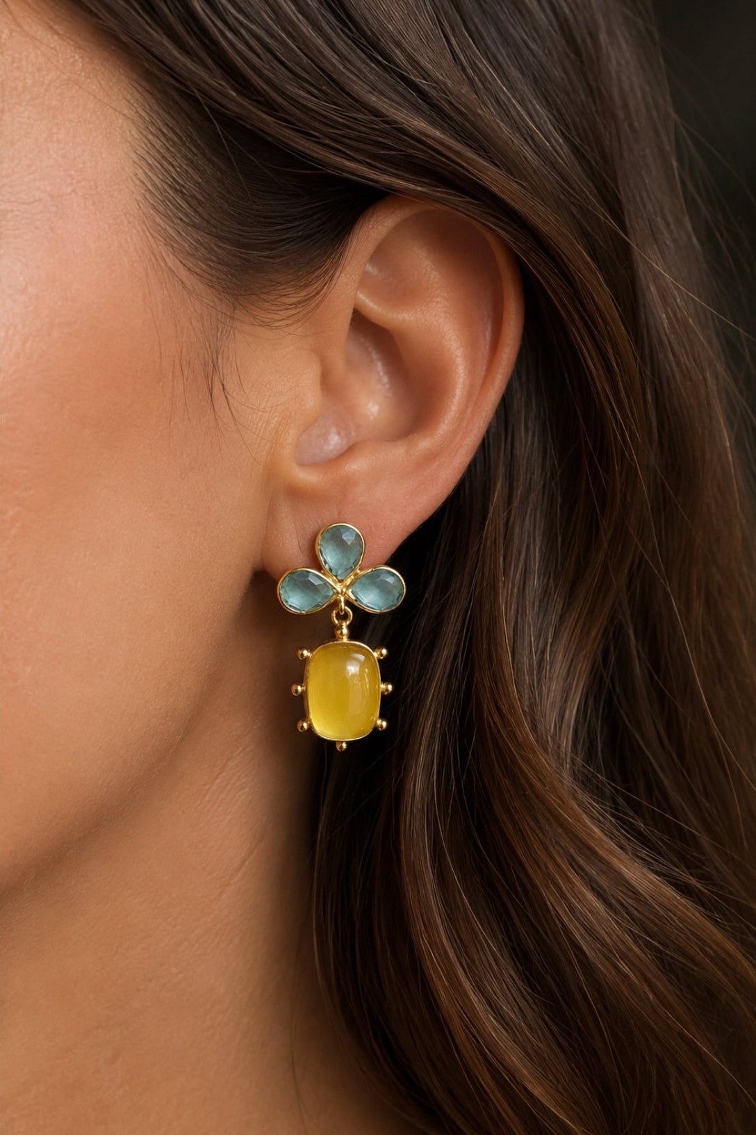 Close-up of a woman wearing a yellow and blue floral earring.