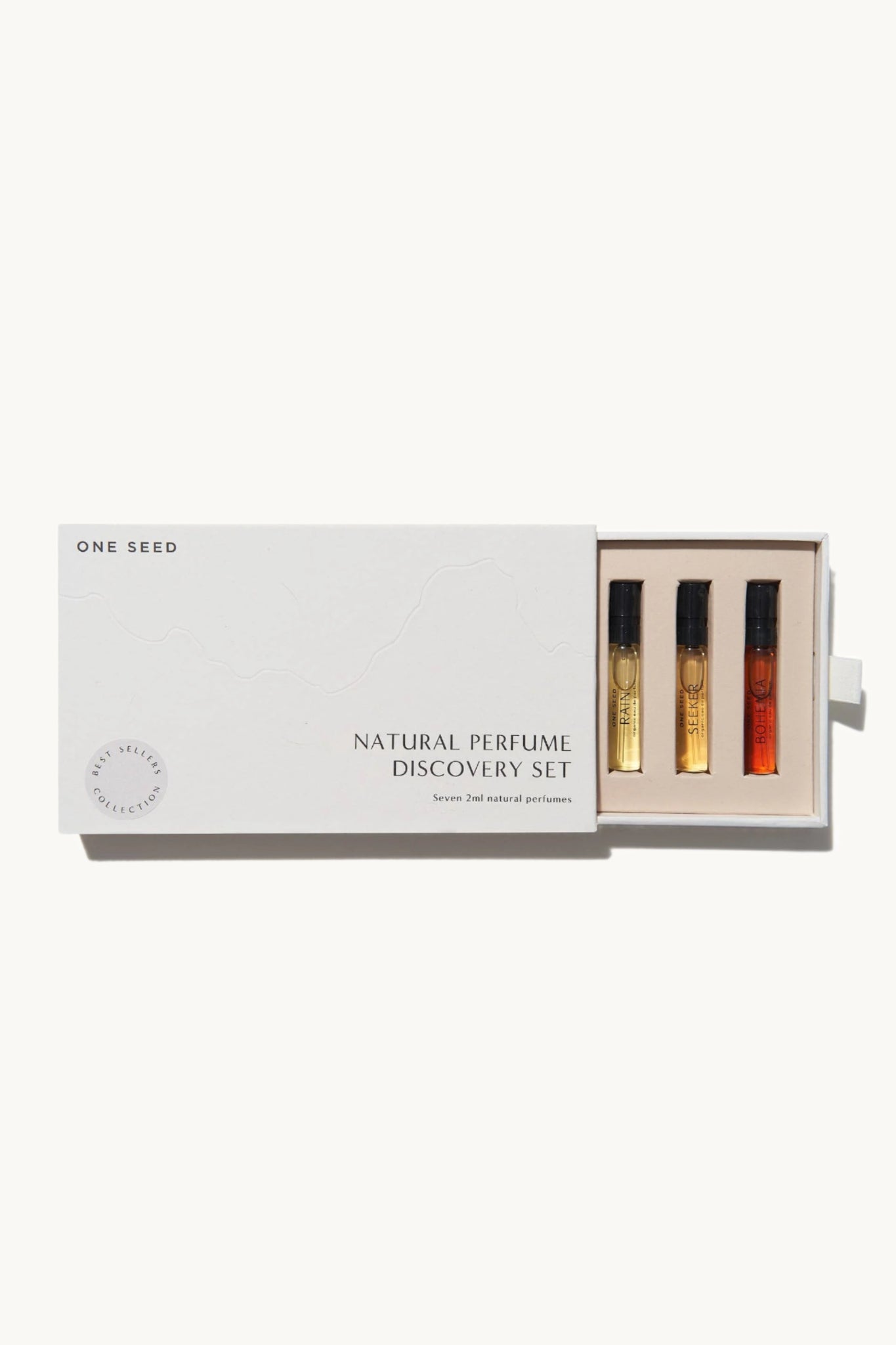 A gift box containing a set of organic perfume discovery samples from One Seed, with seven small, clear atomisers filled with different scents.