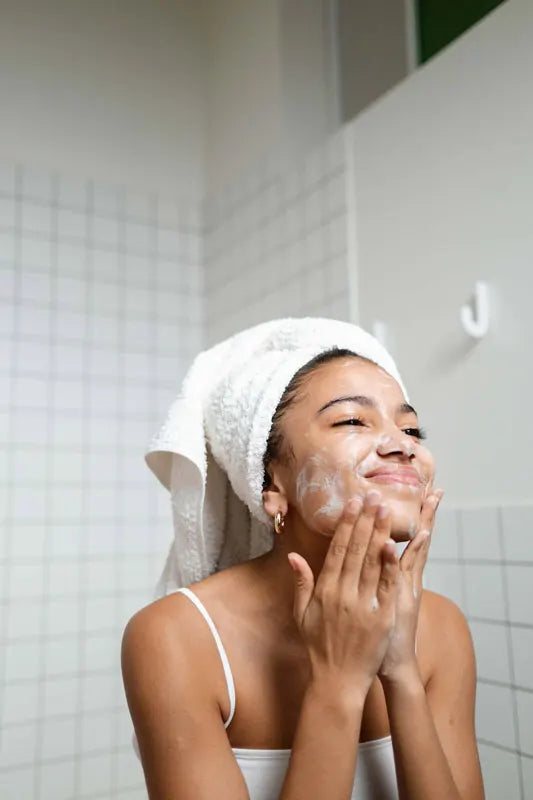 Woman applying cream to her face in a bathroom setting