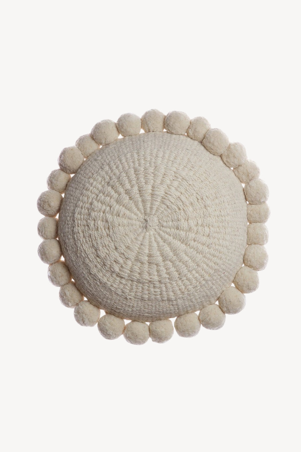 A round woven raw wool throw pillow in a natural cream color, featuring a border of small knotted pom-poms, shown from a top-down view on a solid white background.