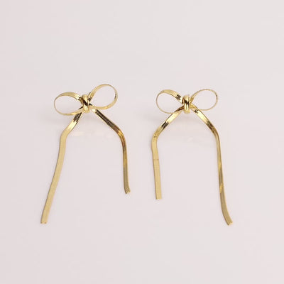 Spinning mini gold herringbone bow earrings.