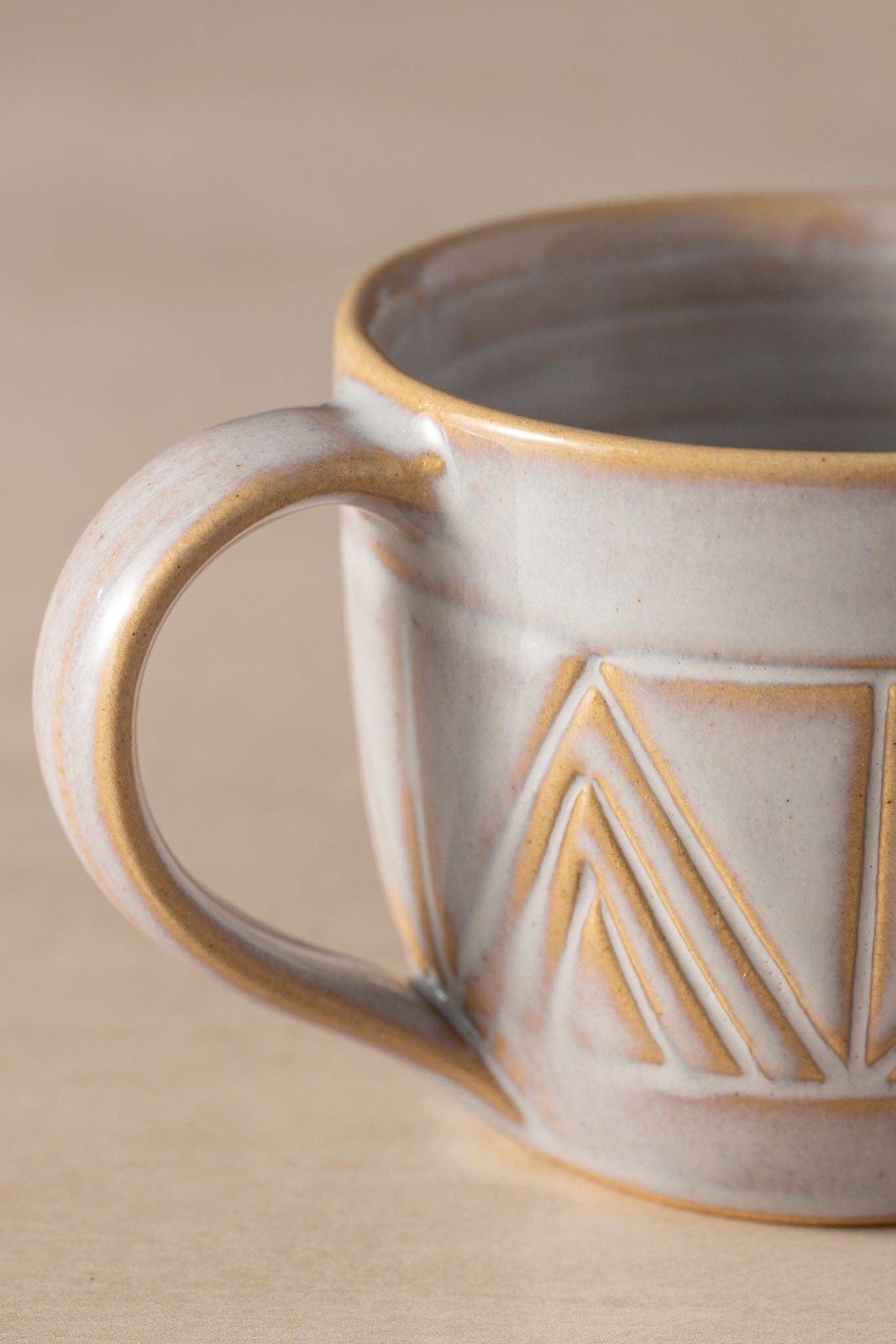 Ceramic mug with geometric pattern on a beige background