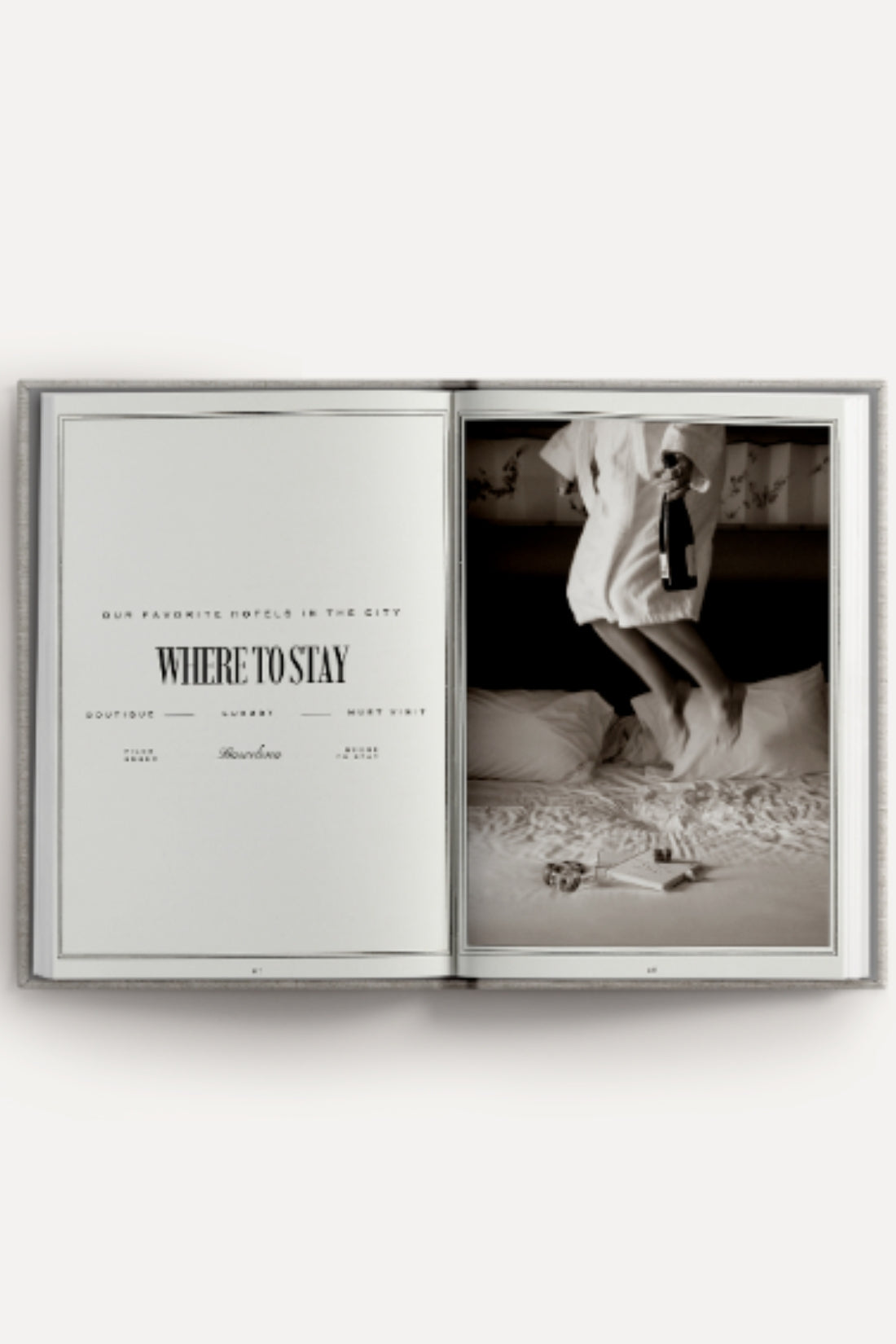 Open book with a black and white photo of a person on a bed, on a white background